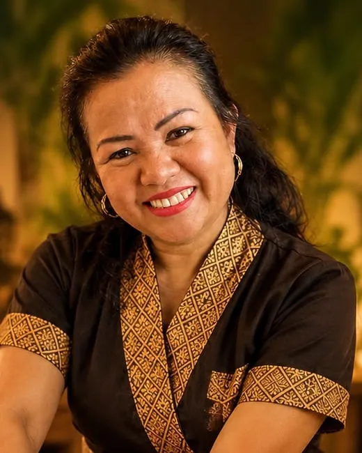 Portret van de masseuse van Pranee Thai Massage in traditionele Thaise werkkledij